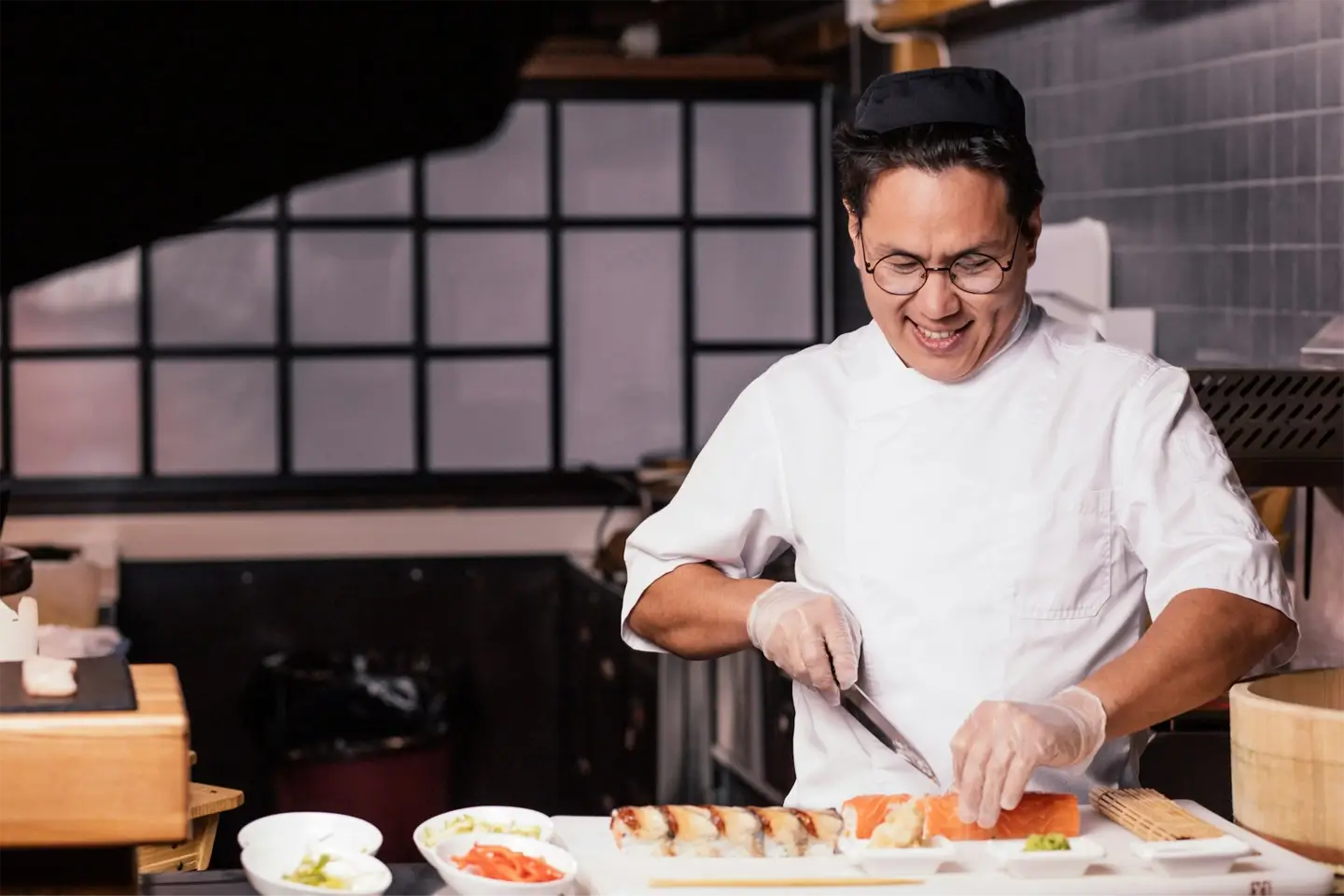 excited young unexperiened chef learning to cut sushi at work