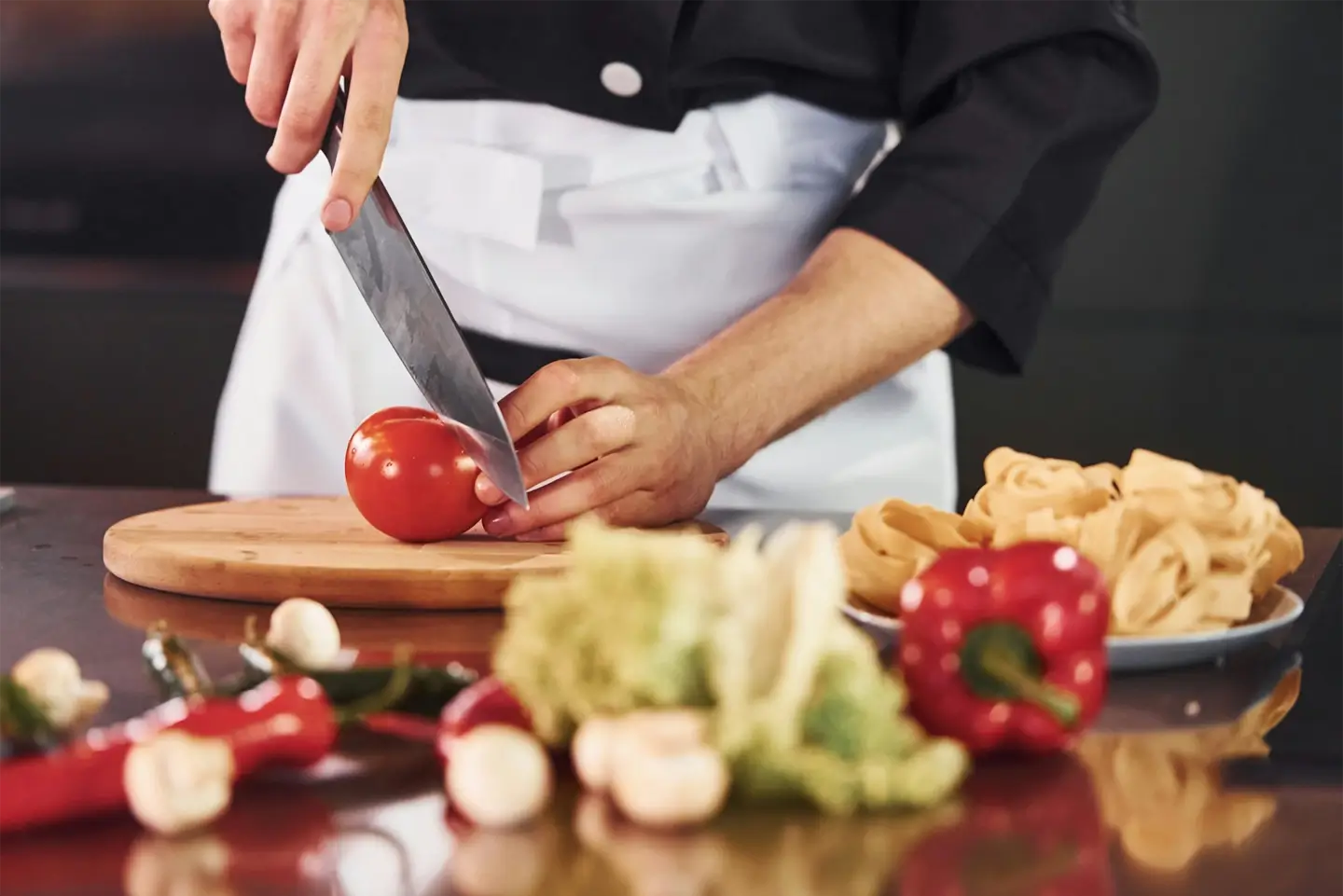 With vegetables. Professional young chef cook in uniform working on the kitchen