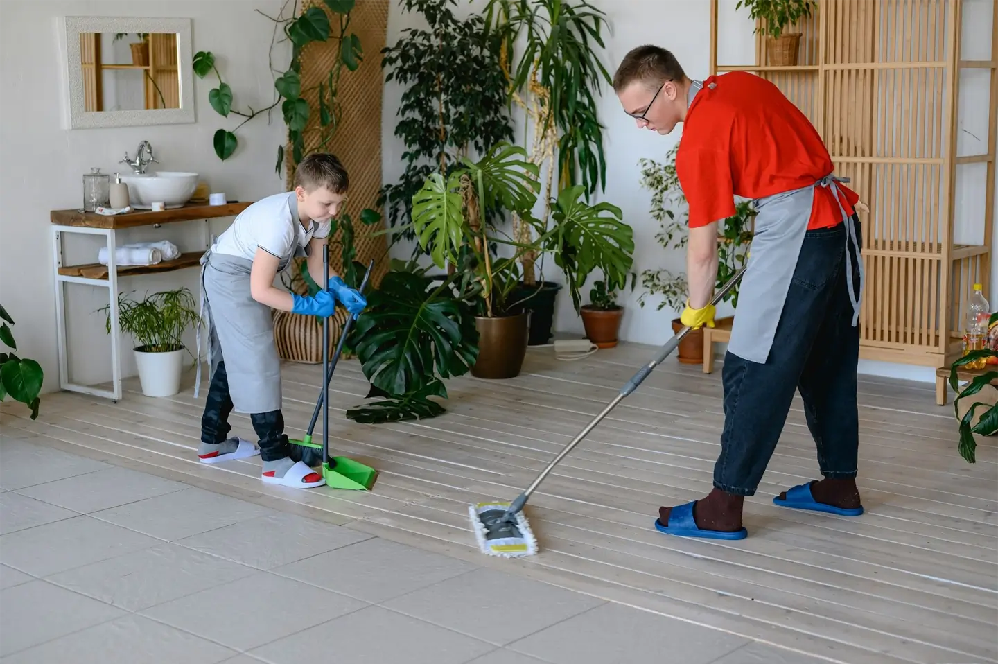 two brothers are cleaning the bathroom, in which there are green plants.