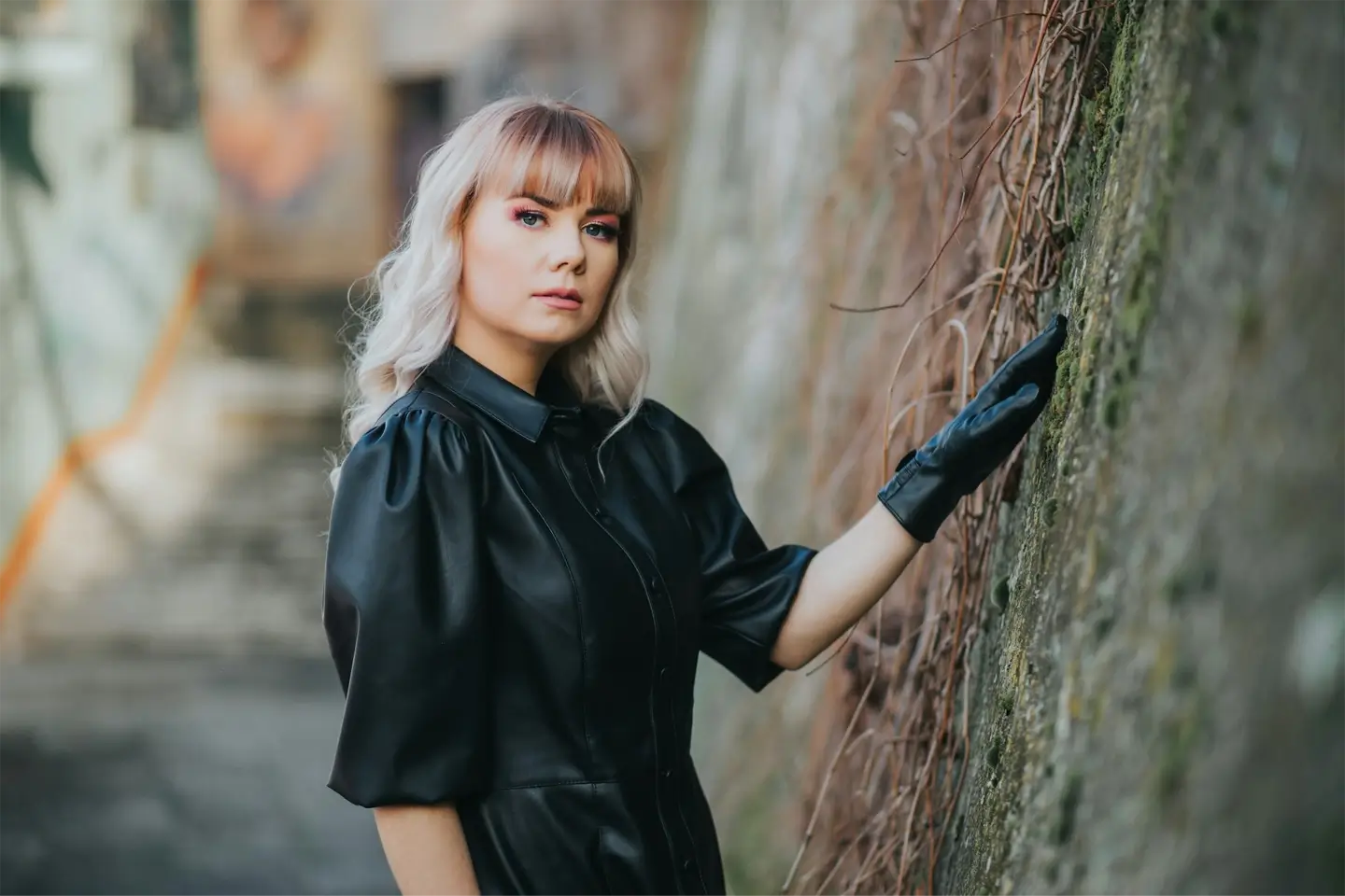 Young caucasian female posing in a fashionable black leather dress