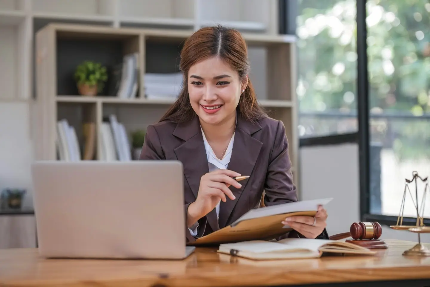 Looking camera. Young Attractive Asian female lawyer working in office with contract and law books