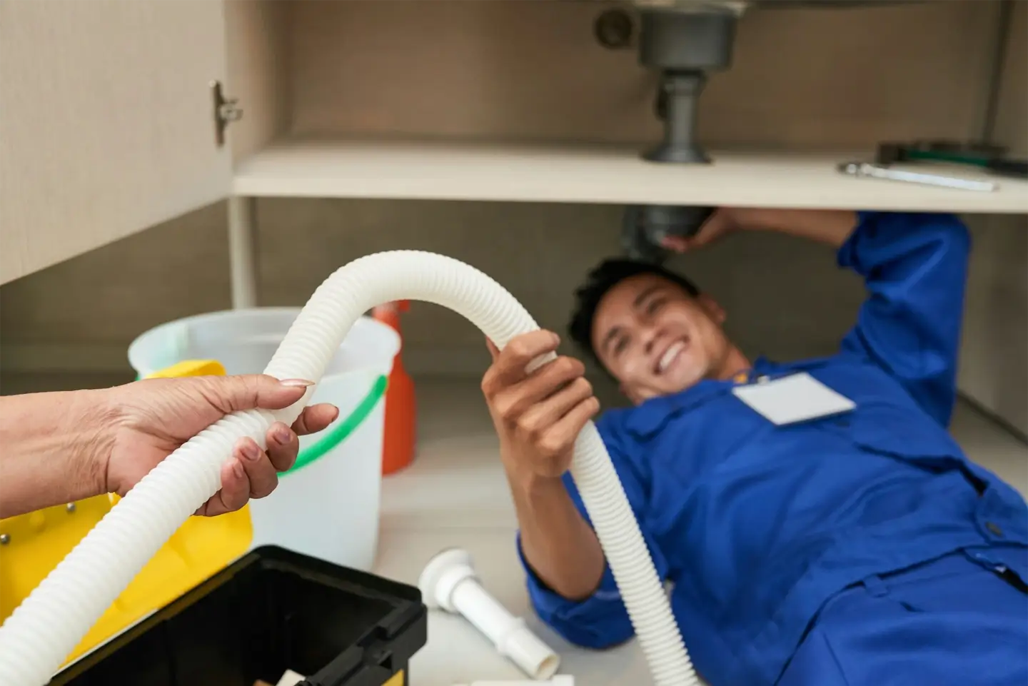 Woman giving plastic pipe to plumber