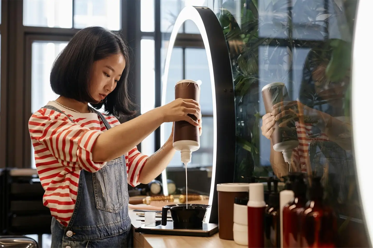 Young Asian Hairstylist Mixing Hair Dye in Beauty Salon